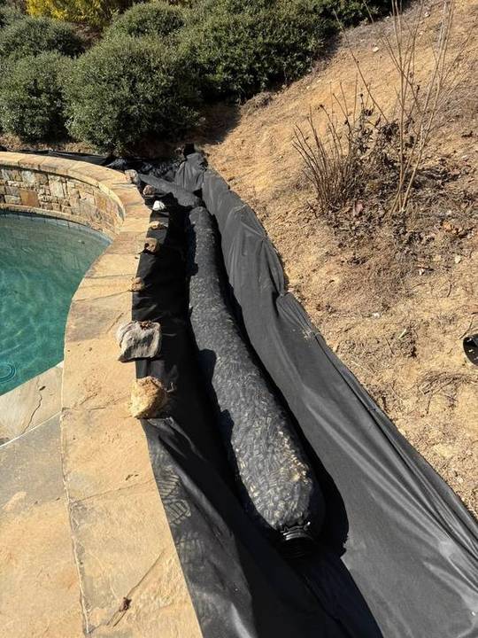 Drain trench lined with filter fabric and washed stone