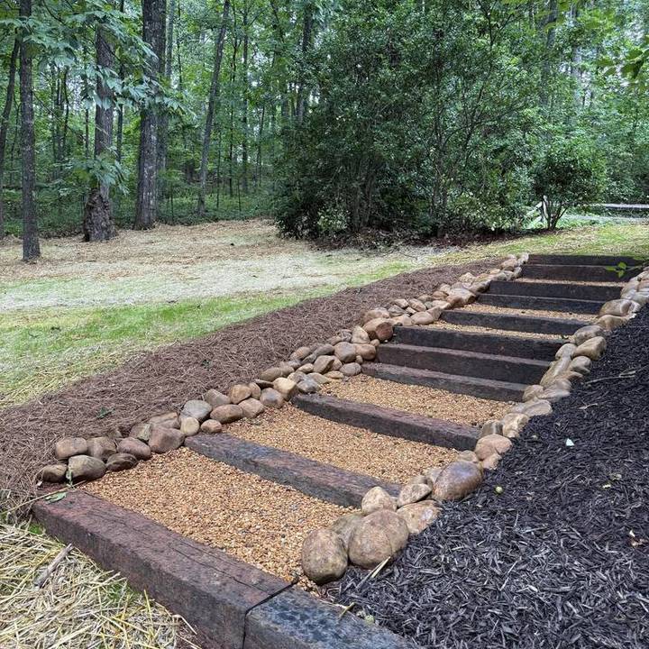 Stone-edged step run through a mulched bed on a sloped lot
